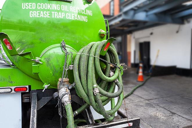 a grease trap being pumped by a sanitation technician in Brookville